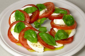 Tomate, mussarela de búfala e manjericão ao molho vinagrete de pesto.